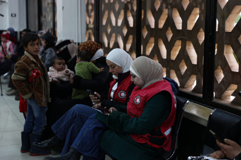 Syrians returning from Lebanon wait at border crossing in Damascus